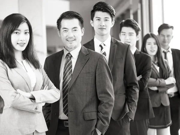 Bir Takım Başarılı Asyalı Işadamları Kameraya Gülümseyen Siyah Beyaz Görünümlü — Stok fotoğraf