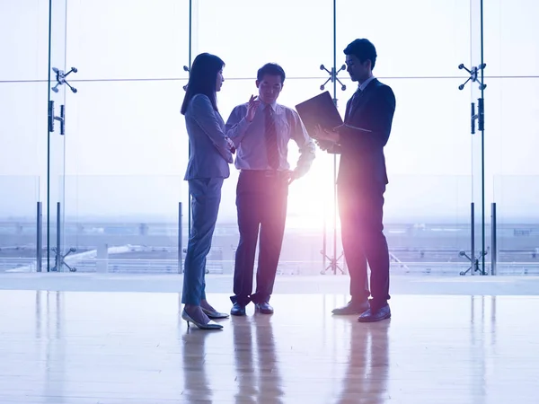 Siluetas Tres Ejecutivos Corporativos Asiáticos Pie Frente Las Ventanas Discutiendo — Foto de Stock