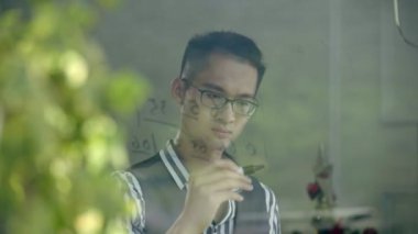 Genç Asyalı müzisyen numaralı nota penceresi cam üzerine yazma.