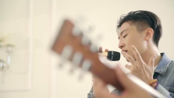 Jovem Asiático Masculino Cantor Ensaiando Com Guitarra Acompanhamento — Vídeo de Stock