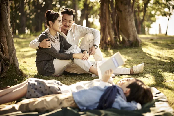 Familia asiática con dos niños relajándose en parque —  Fotos de Stock