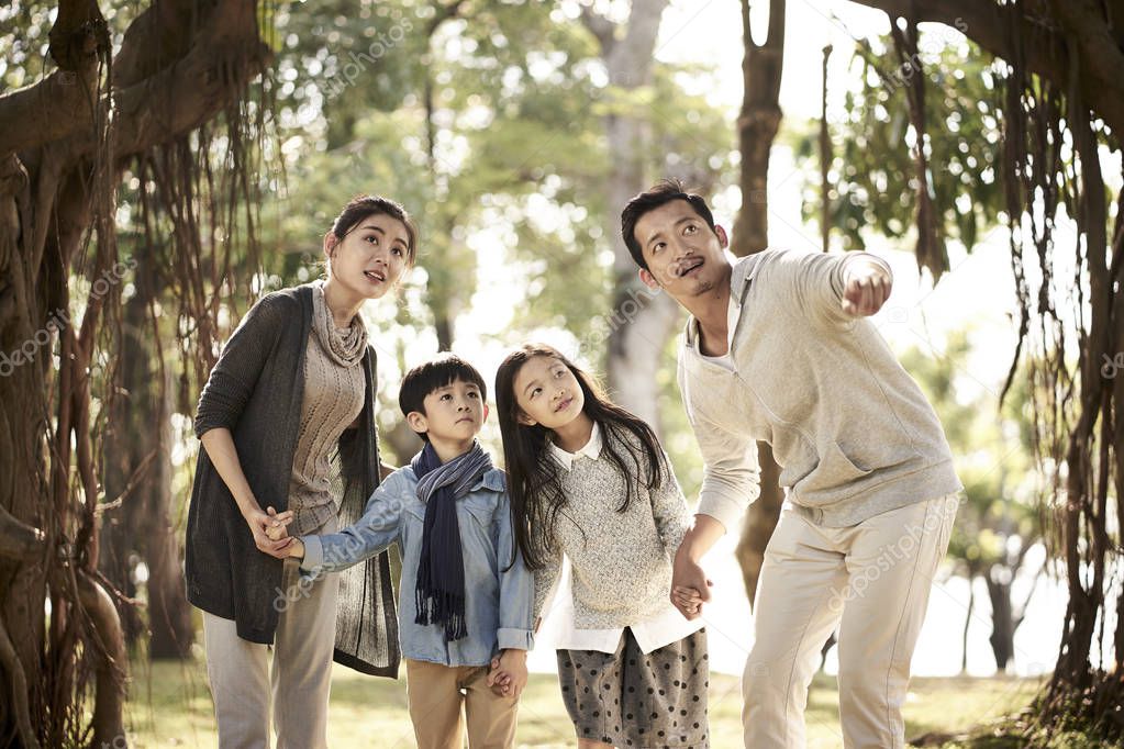 asian family with two children having fun in park