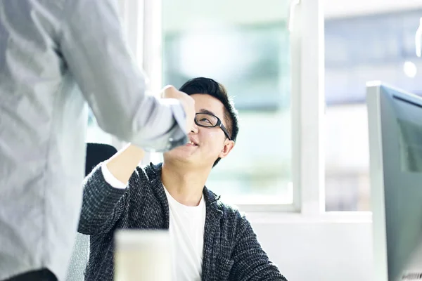 Twee Aziatische zakenlieden stoten vuisten in kantoor — Stockfoto