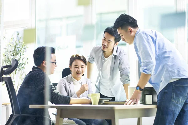 Grupp av fyra asiatiska lagkamrater arbetar tillsammans diskutera affä — Stockfoto