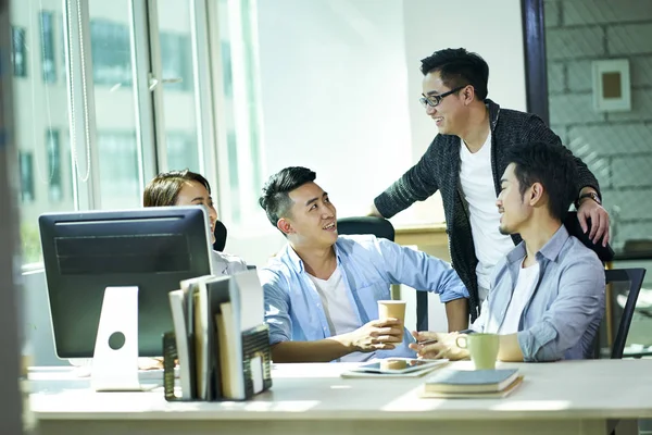 Quatre jeunes asiatiques gens d'affaires bavarder au bureau — Photo