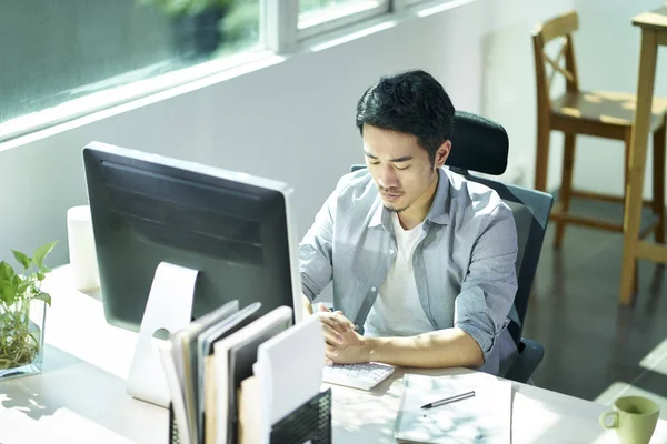 Jovem asiático empresário contemplando no escritório — Fotografia de Stock