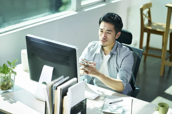 Joven asiático empresario contemplando en oficina — Foto de Stock