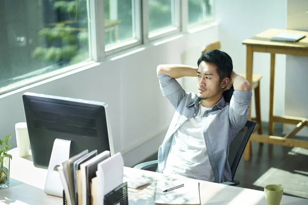 Junger asiatischer Geschäftsmann denkt im Amt — Stockfoto