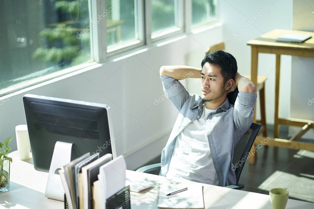 young asian businessman thinking in office