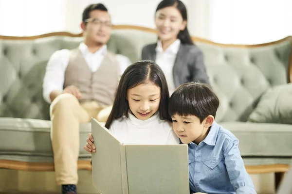 Dos asiático niños lectura libro juntos —  Fotos de Stock