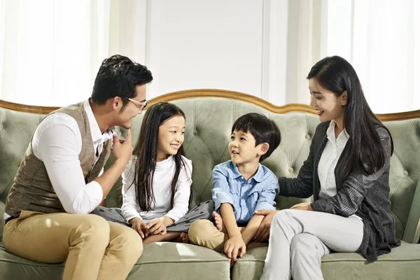 Aziatische ouders en twee kinderen chatten thuis — Stockfoto