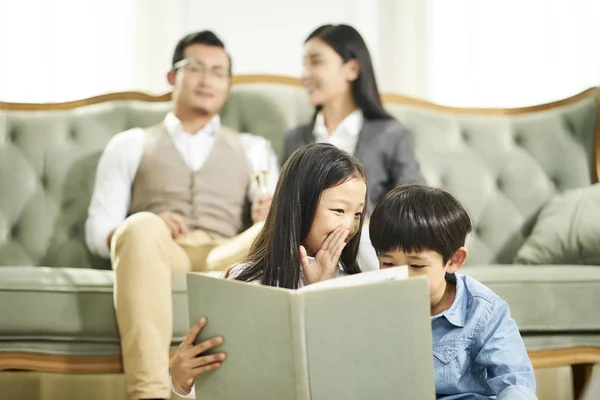 Två asiatiska barn läser bok tillsammans — Stockfoto