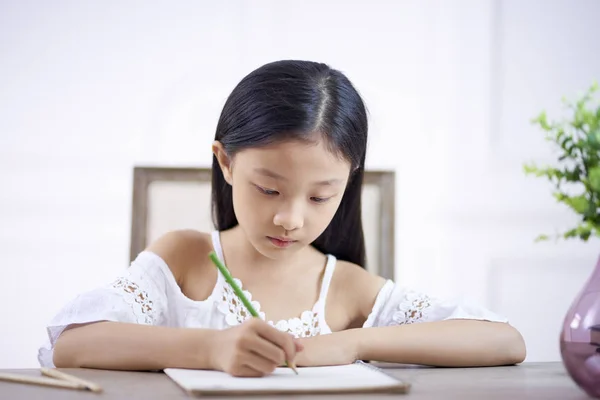 Kleine Aziatische meisje schrijven of tekenen — Stockfoto