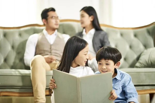 Aziatische broer en zus lezen boek samen — Stockfoto