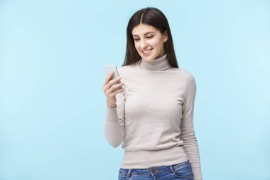 Genç beyaz kadın cep telefonu bakıyor