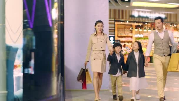 ショッピングモールで手をつないで歩く2人の子供を持つ幸せなアジアの家族 — ストック動画