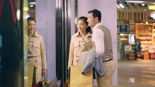 ショッピングモールで店に入る幸せなアジアのカップルの買い物客 — ストック動画