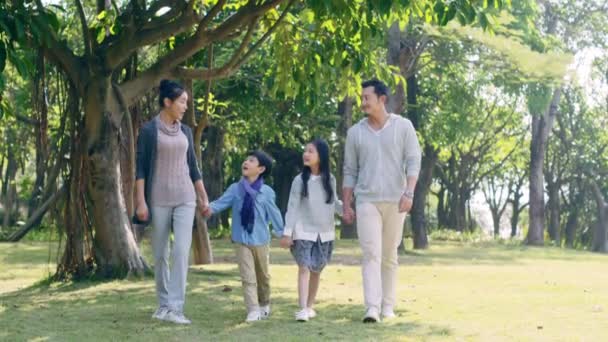 Parkta Rahatlatıcı Ele Yürüyen Iki Çocuklu Asyalı Aile — Stok video