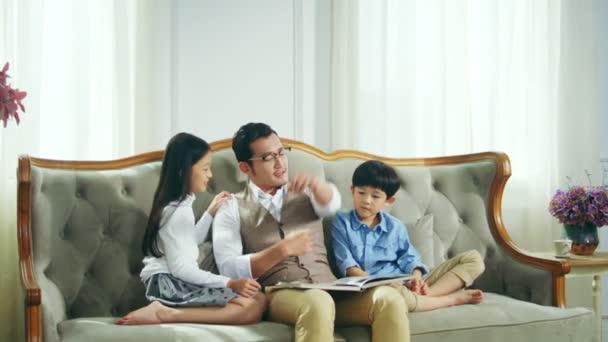 Любящий Отец Азиат Двое Детей Вместе Читают Книгу Рассказывая Историю — стоковое видео