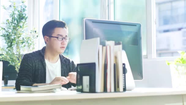 Masaüstü Bilgisayar Kullanarak Ofiste Çalışan Genç Asyalı Adamı — Stok video
