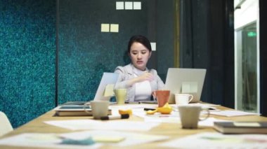 ofiste fazla mesai çalışan yorgun genç Asyalı kadın