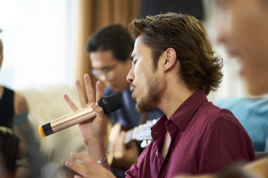 genç asyalı yetişkinler şarkı ve müzik aletleri çalmak