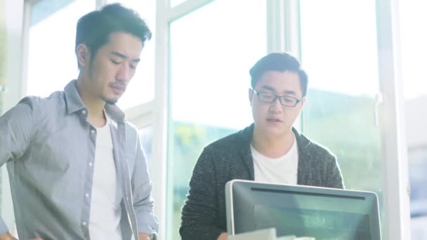Два Молодих Азіатських Підприємці Стоять Столом Аналізуючи Дані Допомогою Настільного — стокове відео