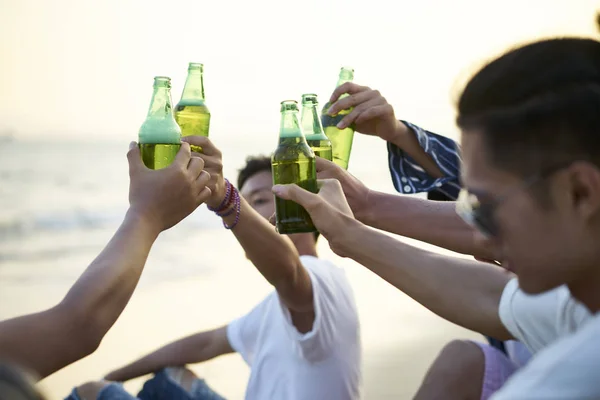 group of asian men drinking beer on beach