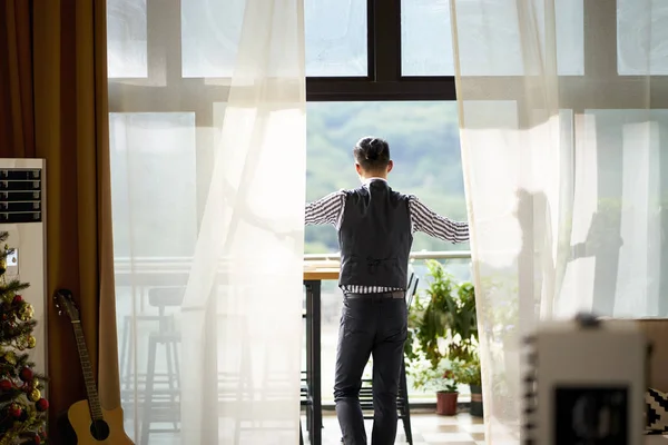 Rear view of a young asian man standing on patio — Stock Photo, Image