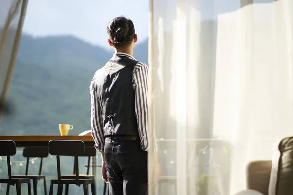 Vista posteriore di un giovane uomo asiatico in piedi sul patio — Foto Stock