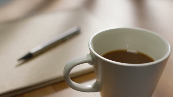 Primer Plano Una Taza Café Escritorio Con Lápiz Cuaderno Fondo — Vídeos de Stock