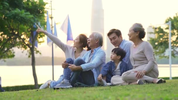 Şehir Parkında Çimlerin Üzerinde Oturup Rahatlayan Mutlu Kuşak Aile — Stok video