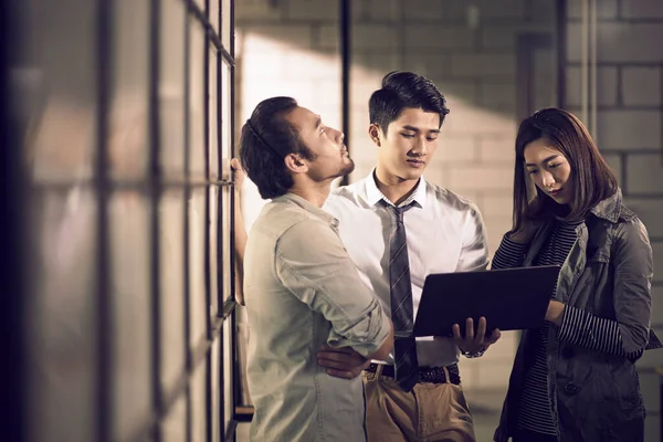 Команда Трех Молодых Азиатских Предпринимателей Встречающихся Офисе Обсуждающих Использование Ноутбука — стоковое фото