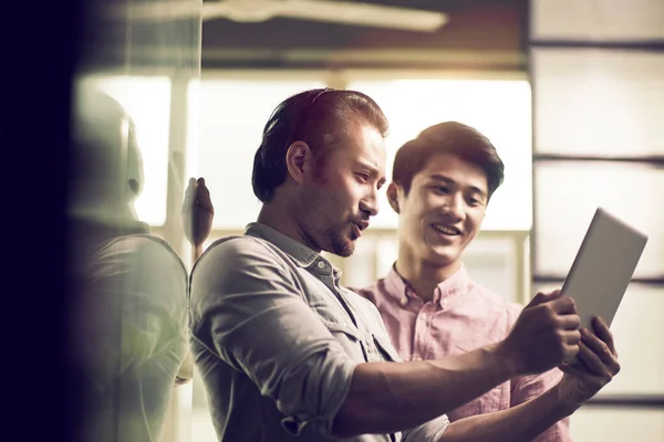 Dwóch Azjatyckich Biznesmenów Pracujących Razem Biurze Patrząc Tablet Cyfrowy — Zdjęcie stockowe