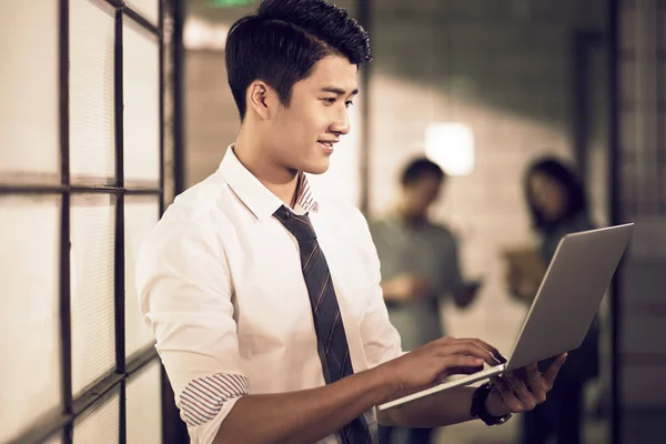 아시아인 사업가는 사무실에서 노트북 컴퓨터를 사용하여 정보나 자료를 — 스톡 사진