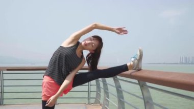 Genç Asyalı kadın ayakkabı bağcıklarını bağlayıp koşuya hazırlanıyor.