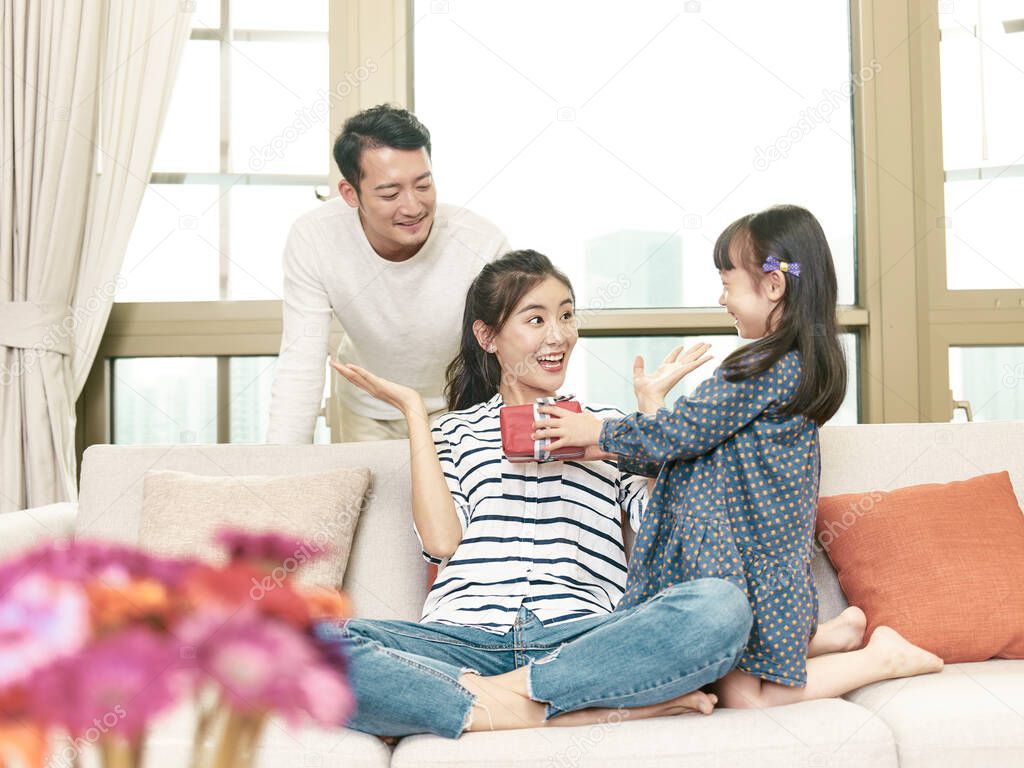 young asian woman receiving a gift from daughter on mother's day