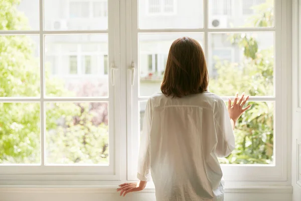 Achteraanzicht Van Een Jonge Aziatische Vrouw Kijken Uit Raam Thuis — Stockfoto