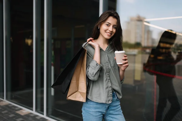 Pretty Woman Krásným Úsměvem Chůzi Ulici Nákupní Tašky Šálek Kávy — Stock fotografie