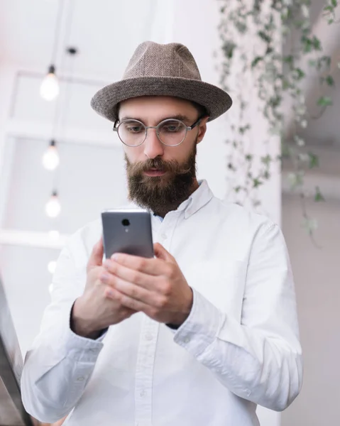 Beyaz Gömlek Şapka Şık Gözlük Smartphone Aygıtı Kullanarak Çekici Sakallı — Stok fotoğraf