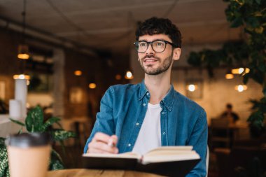 Proje, planlama, üniversite öğrencisi rahat kıyafetler ve dilleri öğrenme, şık hipster gözlük takıyor duygusal güler yüz ile çatı modern kitaplığında Not yazmak. Eğitim kavramı. Bilgi. 