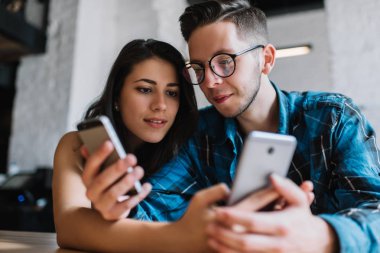 Alışveriş online akıllı telefonlar kullanarak, bilgi online araştırma, dil, öğrenme şık hipsters arkadaşlar. Birlikte oturan, okuma, modern kahve dükkanı projede planlama yaratıcı iş arkadaşları. 