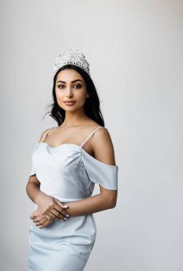Zarif moda elbiseler giyen neşeli Asyalı kadın güzellik yarışmasını kazandığı ve elmaslı taç giydiği için ödül alıyor. Fotoğraflar için poz veren çekici bir mankenin portresi. Taçlı güzellik kraliçesi. 