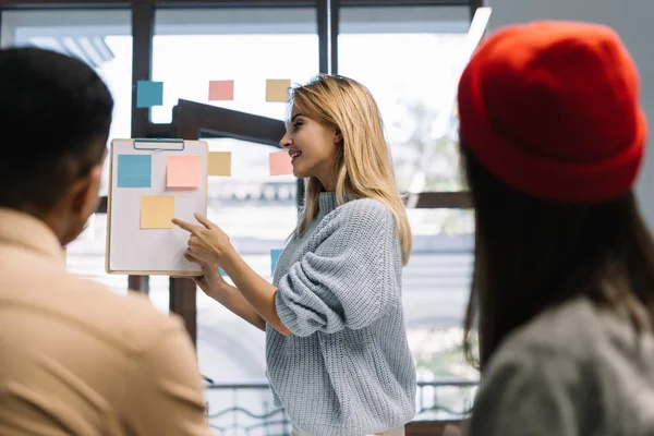 Scrum eğitimde kullanarak dil öğrenme Üniversitesi öğrenci grubu. İşbirliği yapın. Beyin fırtınası. İletişim. Çalışma arkadaşları birlikte loft modern ofis proje. Genç öğretmen gösteren parmak üzerinde yapışkan not. 