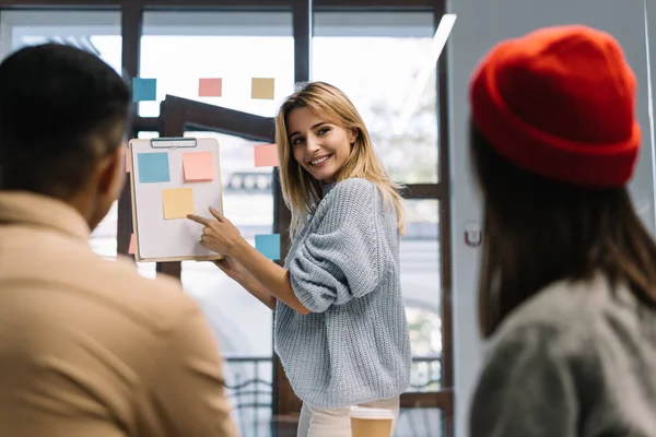 Creative team working together for startup project in modern office. Team building. Strategy planning. Brainstorming. Collaborate. Talented scrum master showing finger on sticky note, helping team reach consensus. Successful business. Career