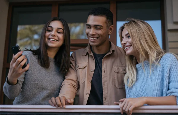 Glückliche Multiethnische Hipster Mit Emotional Lächelnden Gesichtern Die Ihr Smartphone Stockfoto