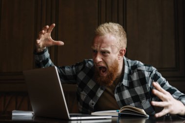 Serbest meslek sahibi proje, o sinirli ve gergin için son tarih cevapsız büyük sorunlar. Sakallı adam yüksek sesle bağırarak dizüstü bilgisayar ekranında, duygusal yüzle işten kovdu. Başarısızlık iş kavramı. 