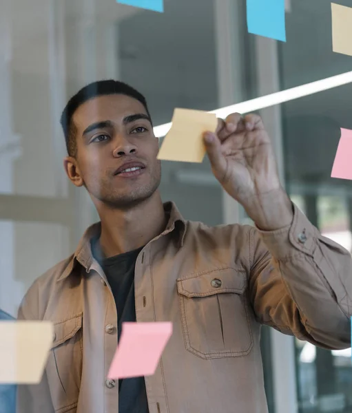 Portrait of handsome African American university student studying, working project, exam preparation, learning language, searching information using scrum and sticky notes at workplace. Brainstorming