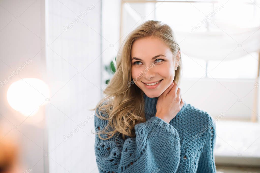 Cheerful happy fashion model smiling. Sensual woman posing for pictures at cozy home. Authentic portrait of positive female with perfect skin and beautiful body.  Skincare concept. 