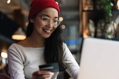 Para tasarrufu bu kadar para ile indirimli satış, düşük fiyatlar, alışveriş online kredi kartı, dizüstü bilgisayar kullanarak tutan güzel bir kadın. Para geri kavramı. İşyerinde mutlu Asya freelancer portresi